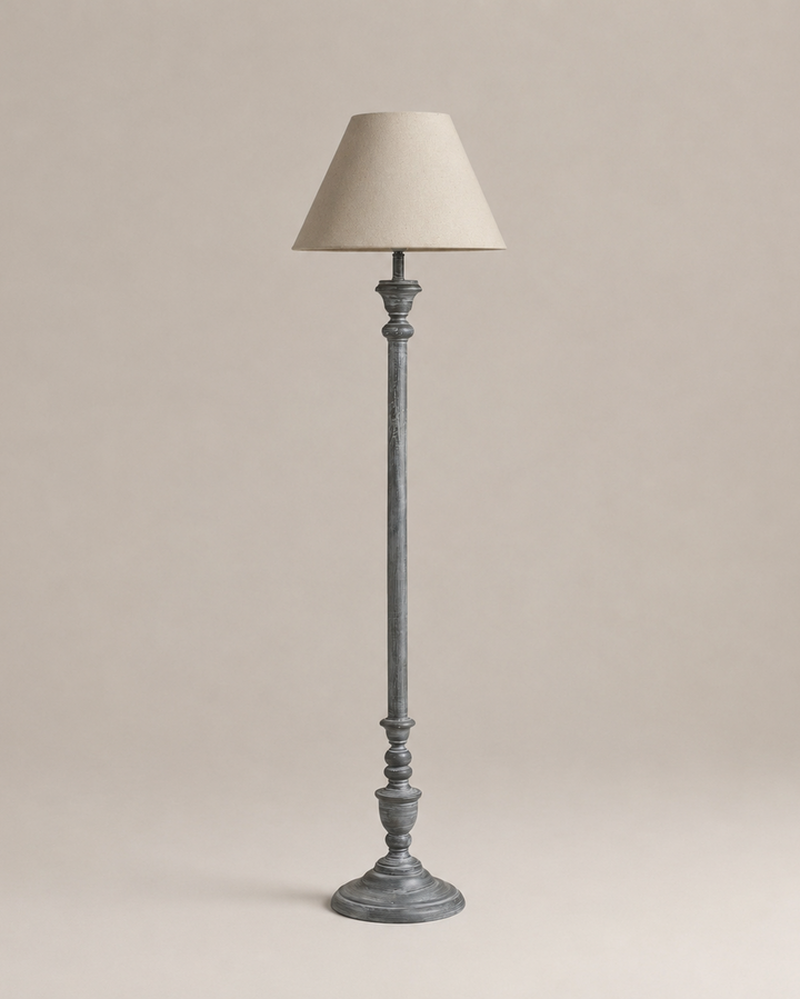 Floor lamp with a beige shade on a plain background