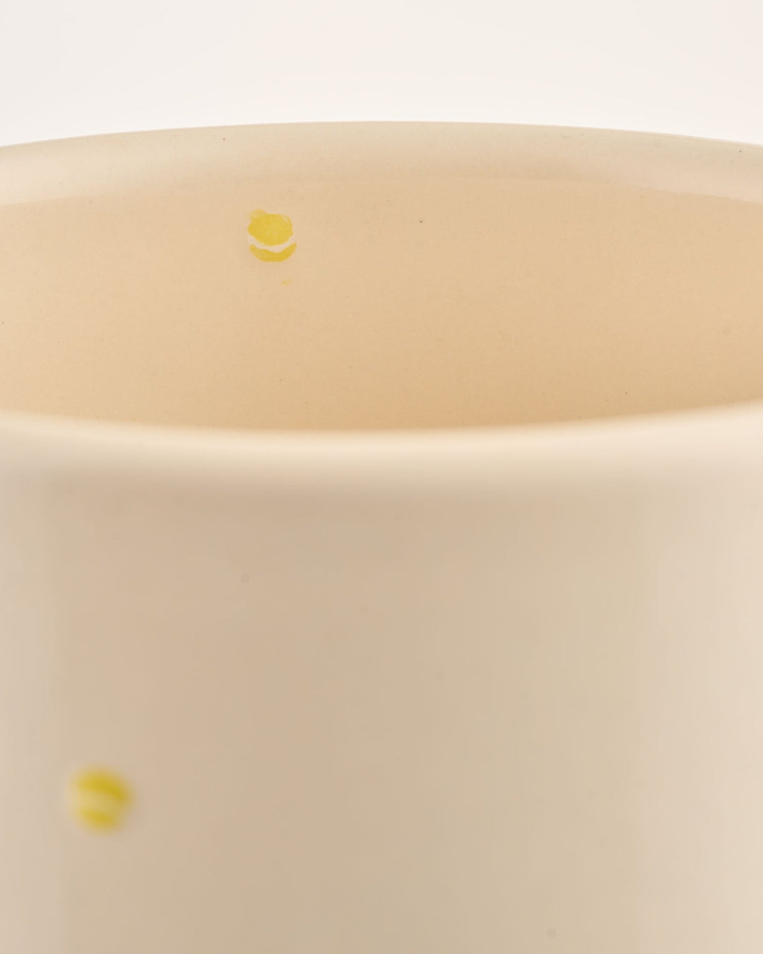 Close-up of a beige ceramic wine cooler with small yellow tennis ball illustrations