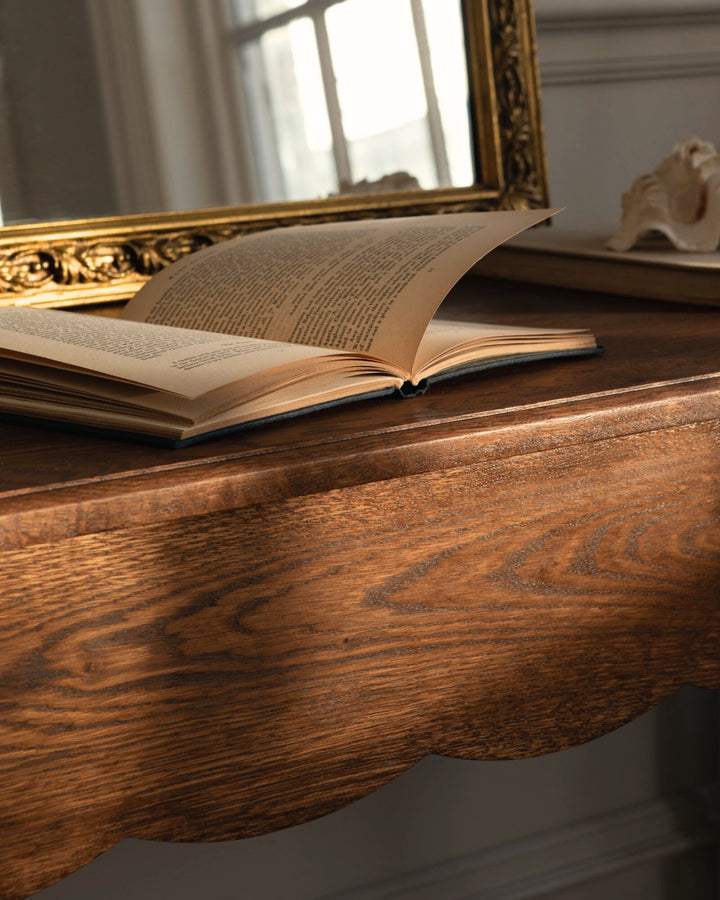 Open book on a wooden  with a mirror in the backgroundable