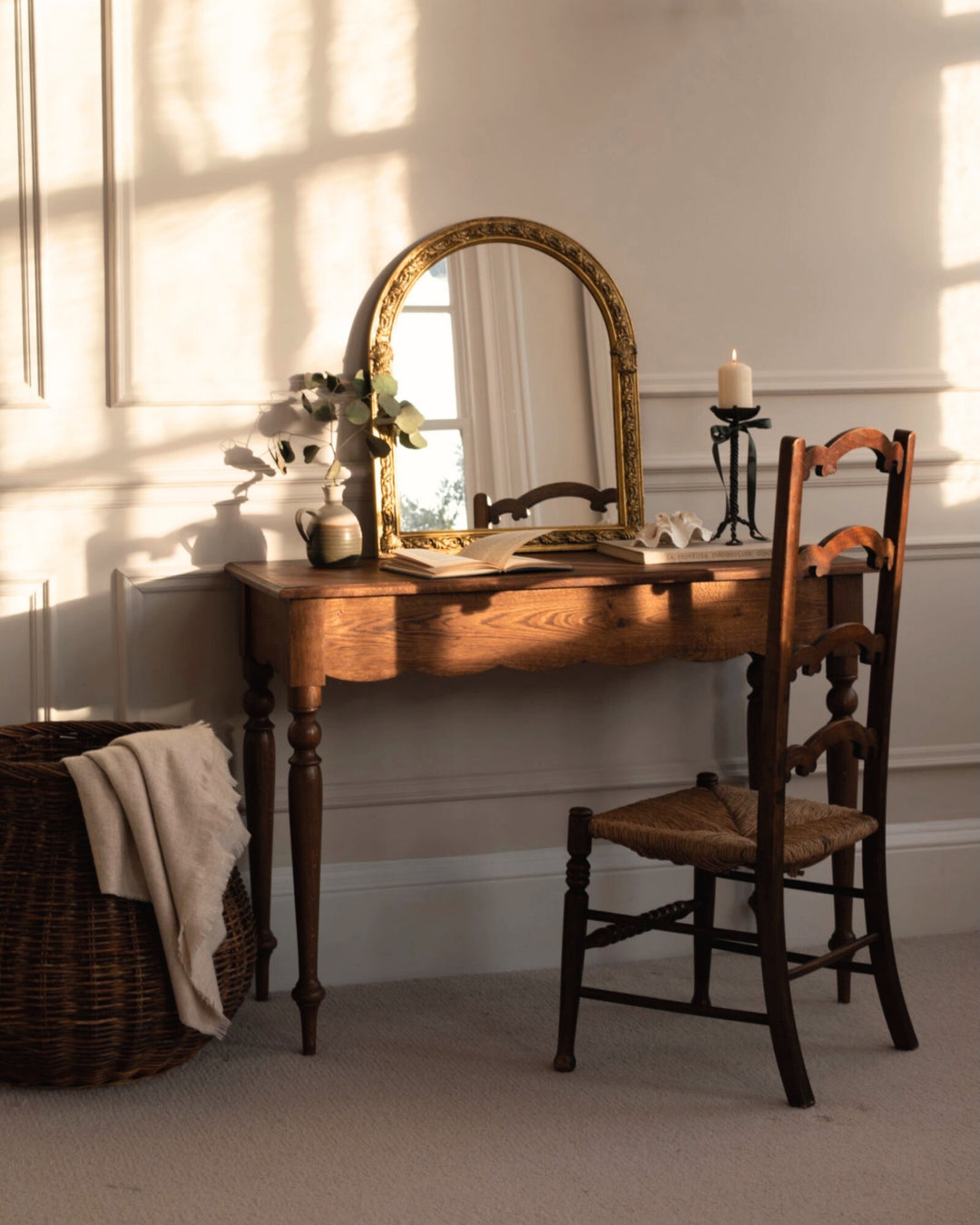Wooden vanity table with mirror and chair in a softly lit room