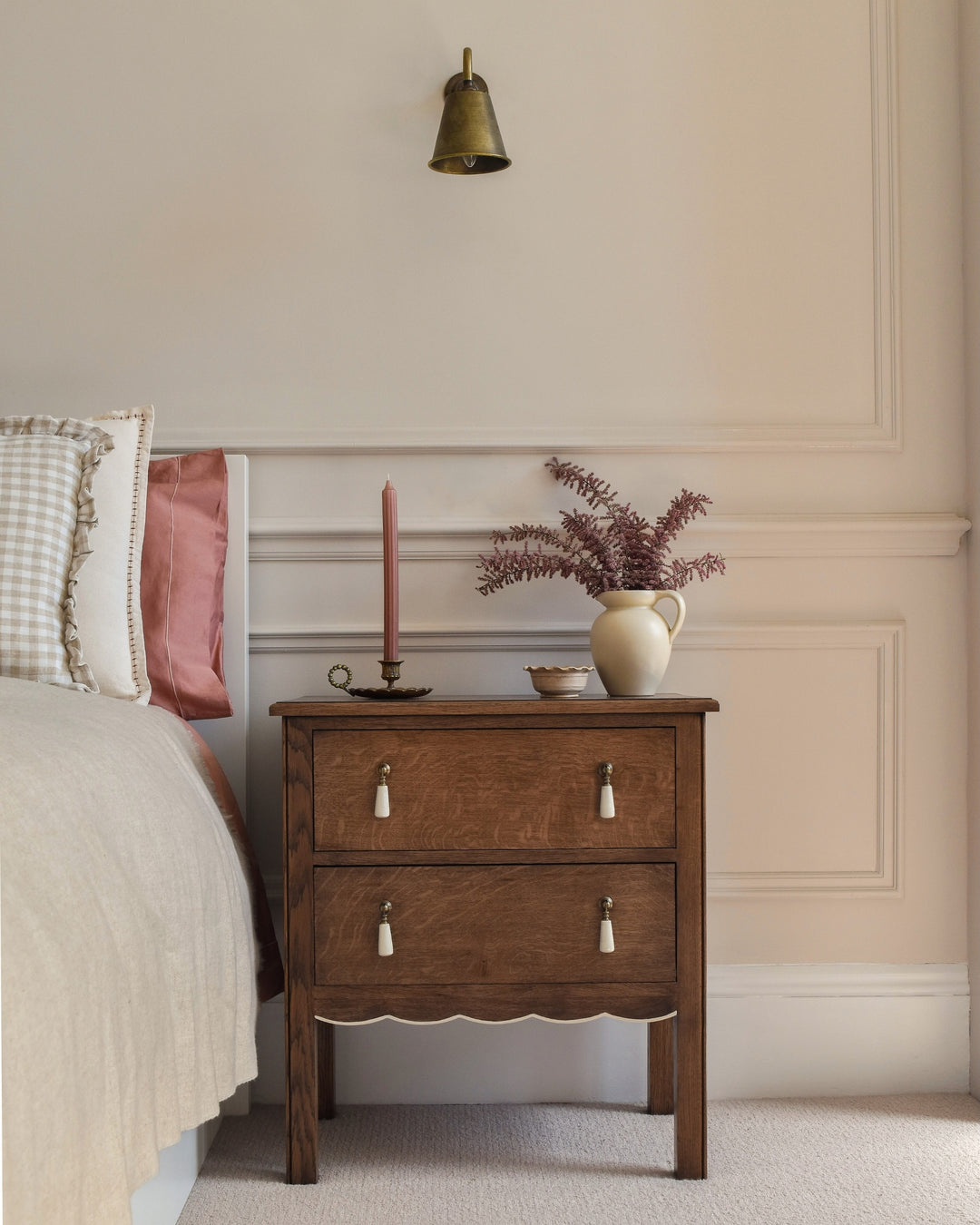Wooden nightstand with decorative items in a bedroom setting