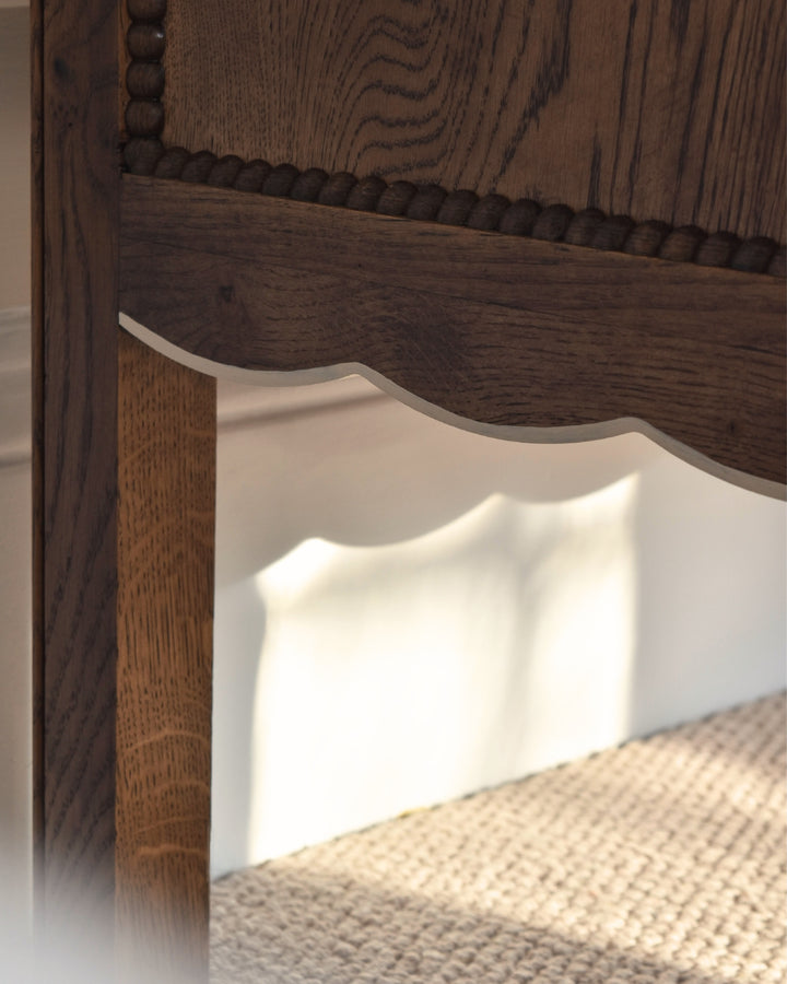 Close-up of a wooden bedside table with a textured finish.