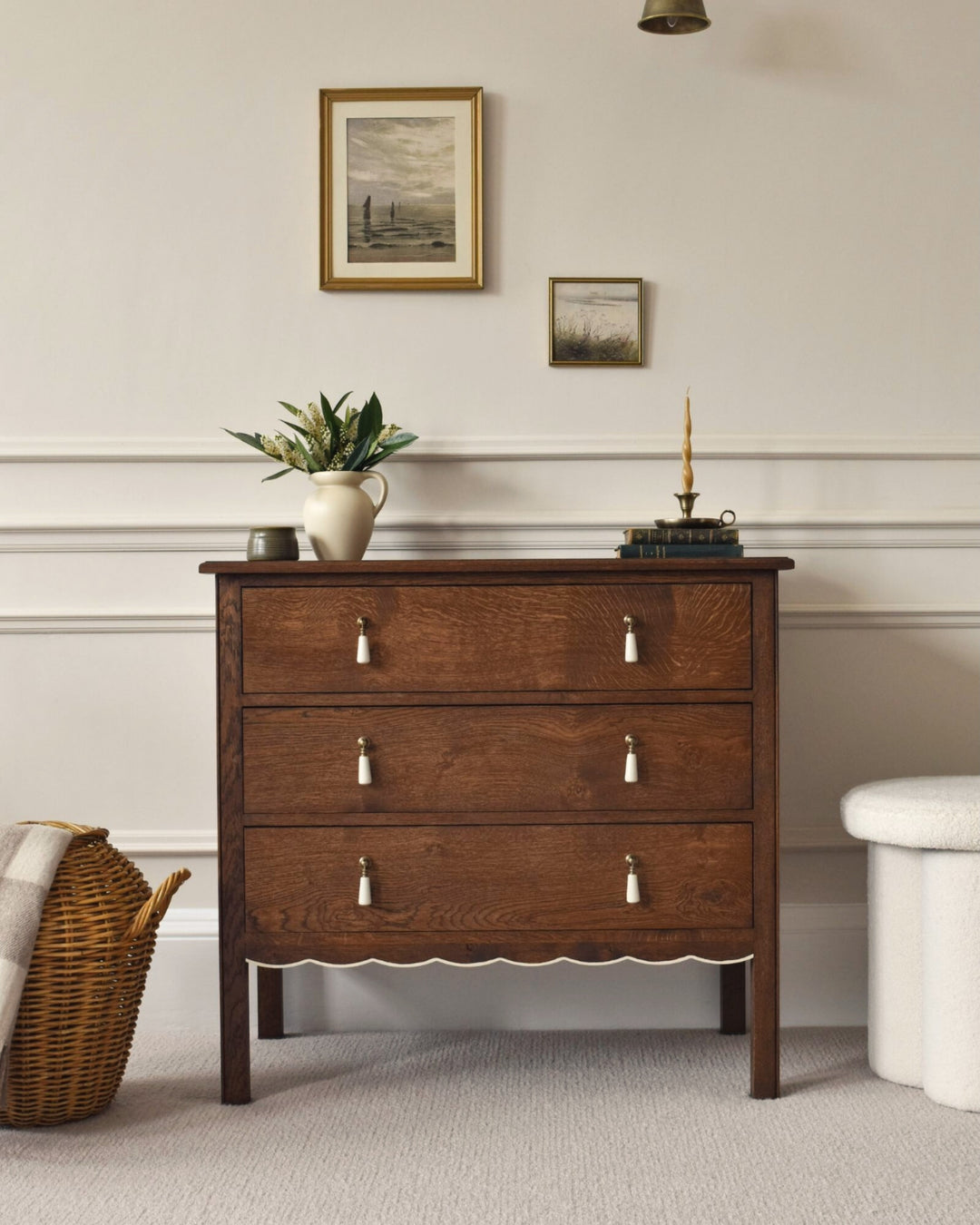 Wooden dresser with decorative items in a room with framed pictures on the wall.