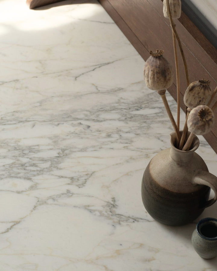 Decorative vase with dried plants on a marble surface