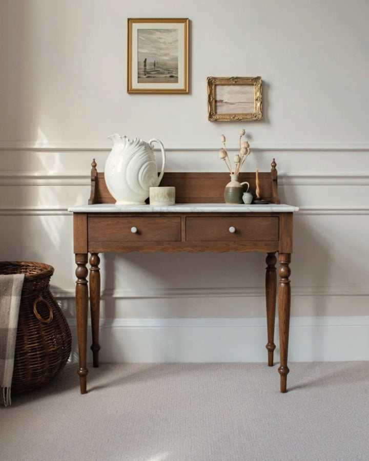 Wooden side table with decorative items against a white wall