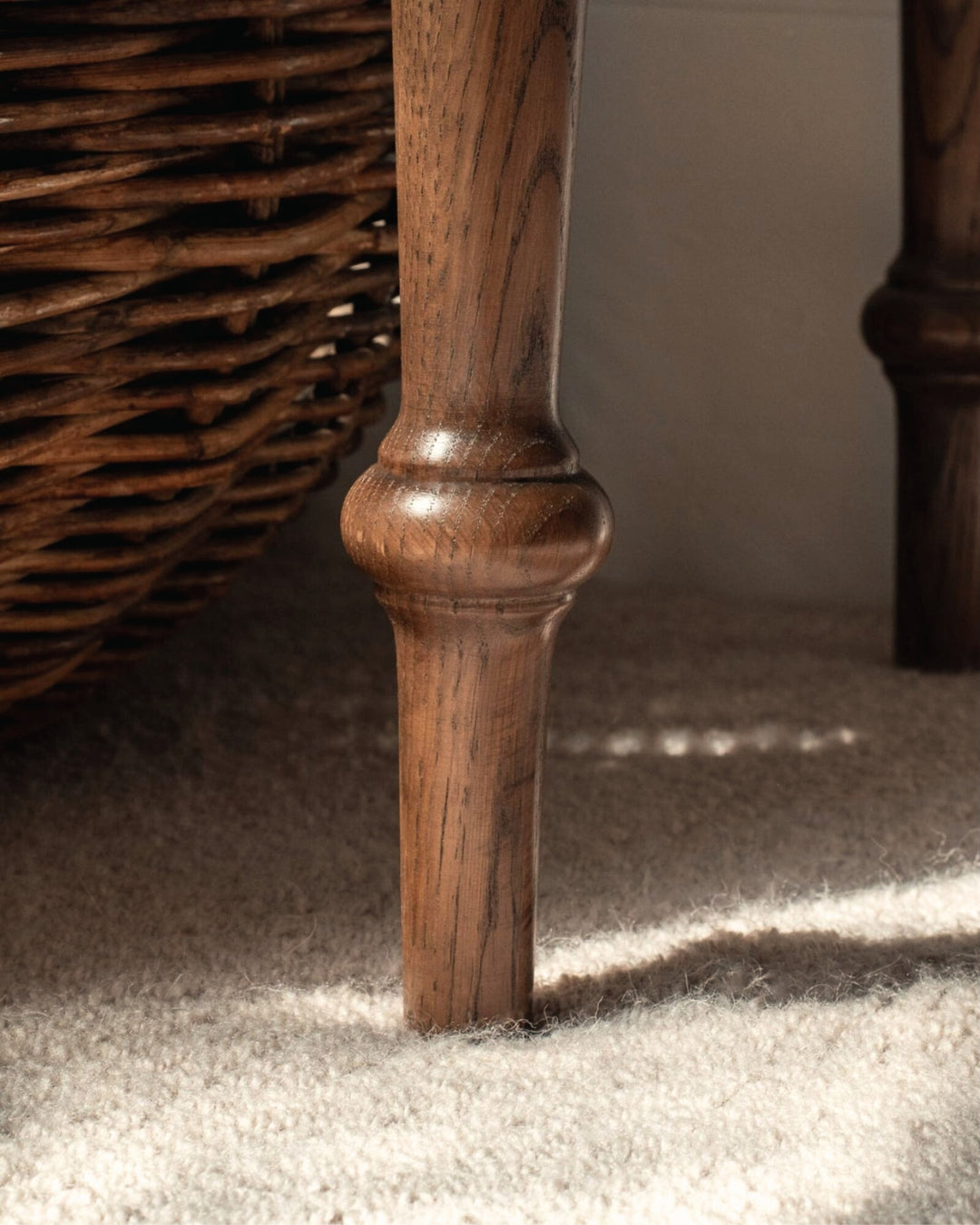 Close-up of a wooden desk leg on a carpeted floor