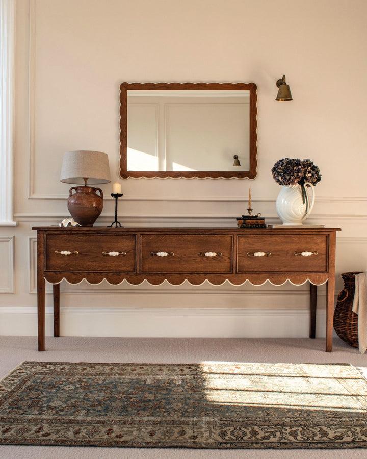 Wooden console table with decorative items in a room setting