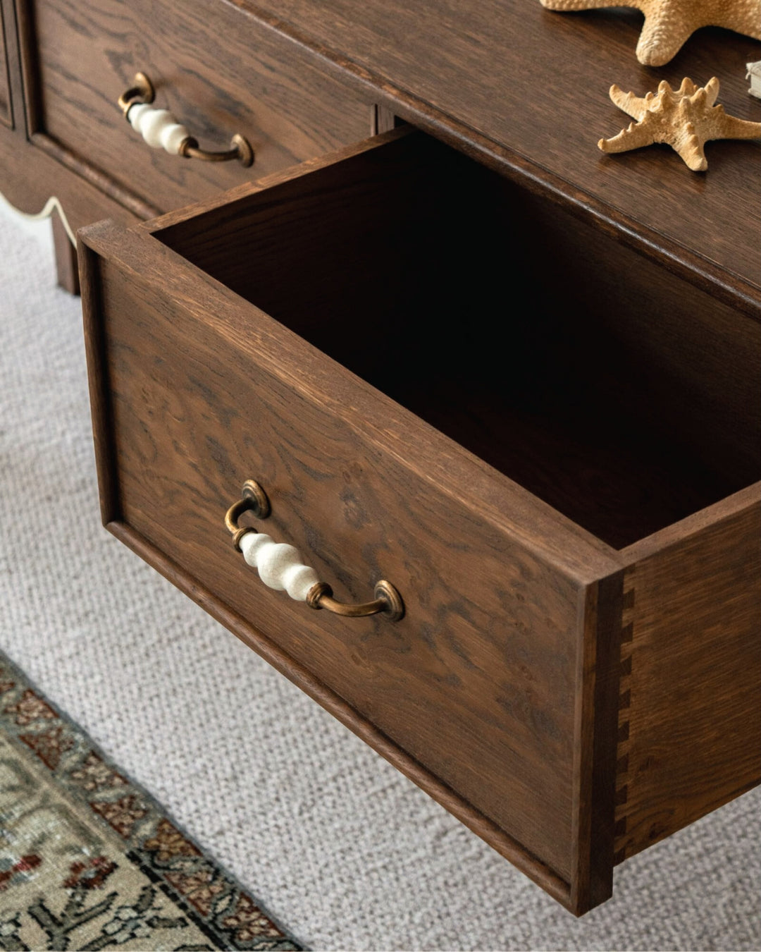 Wooden drawer with decorative handles on a textured surface
