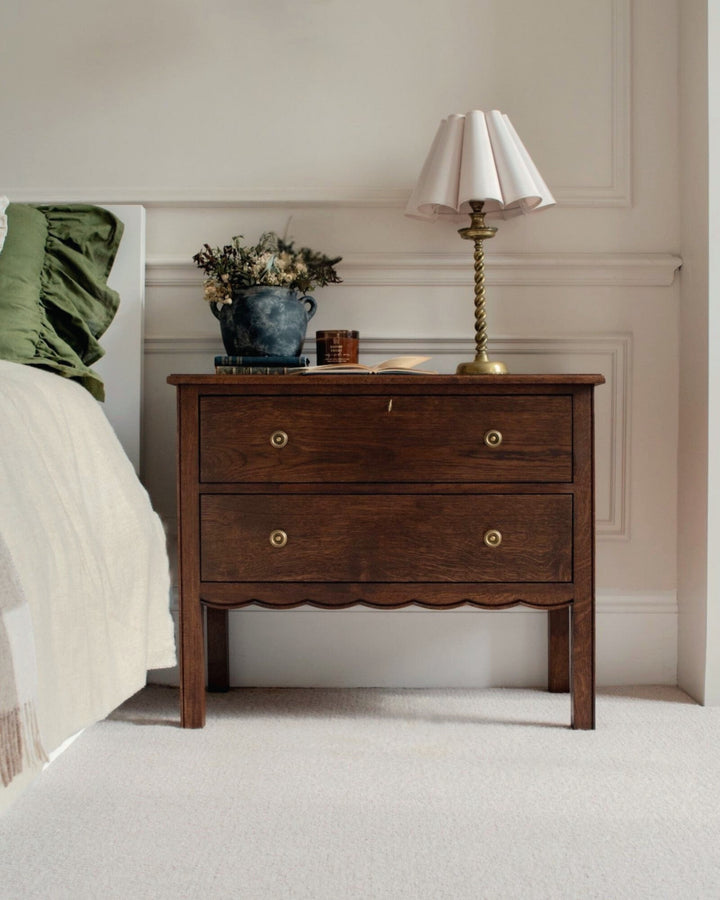 Wooden nightstand with decorative items in a bedroom setting