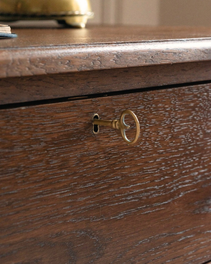 Close-up of a wooden drawer with a brass keyhole.
