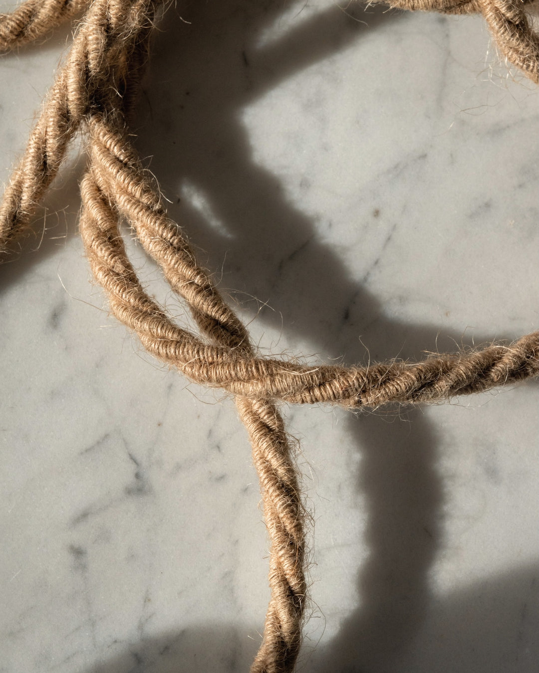 Close-up of braided jute rope on a marble surface