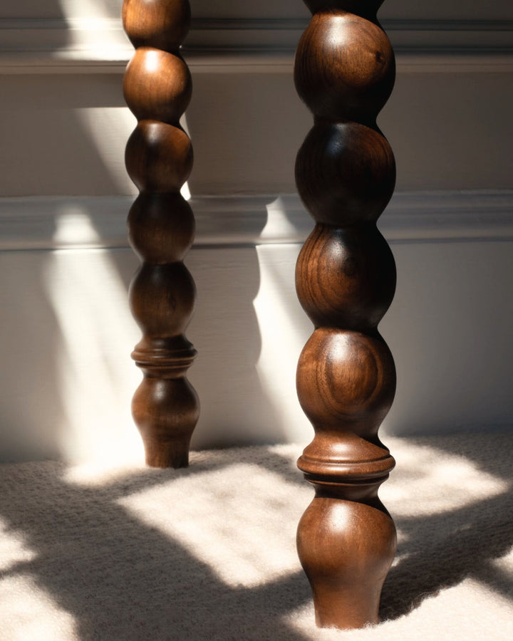 Two wooden balusters with a textured finish on a light background