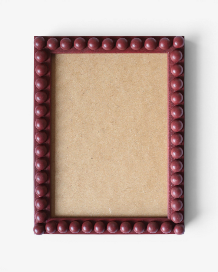 Square brick red picture frame with a decorative border bobbin on a white background