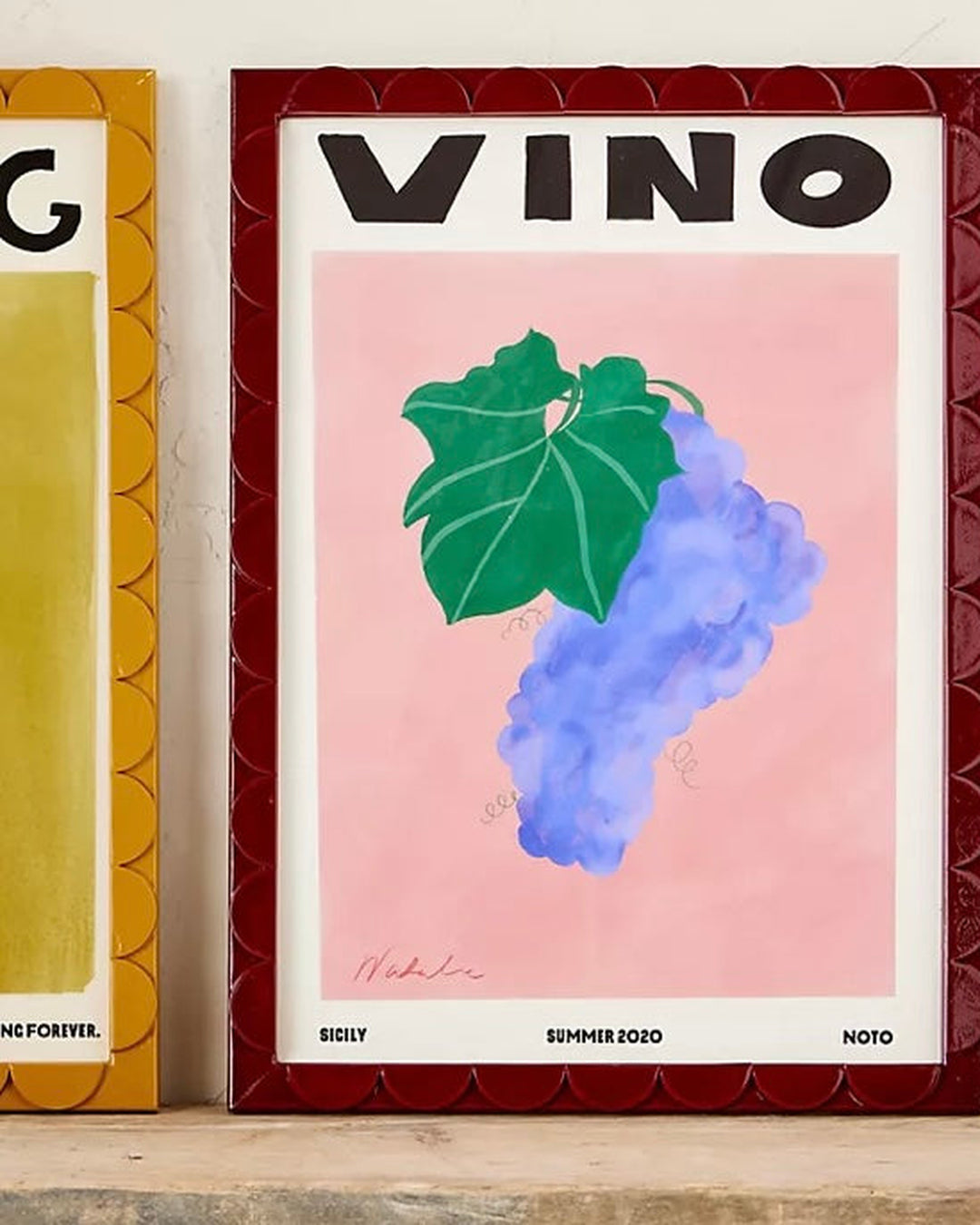 Framed poster with 'VINO' text and grape illustration on a pink background