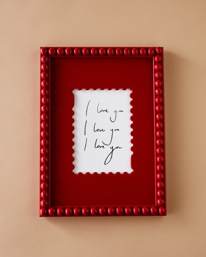 Red framed picture with 'I love you' text on a beige background
