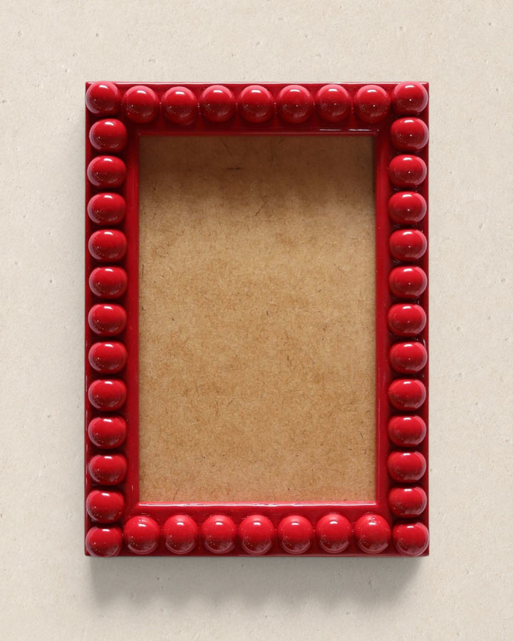 Red beaded picture frame on a beige background