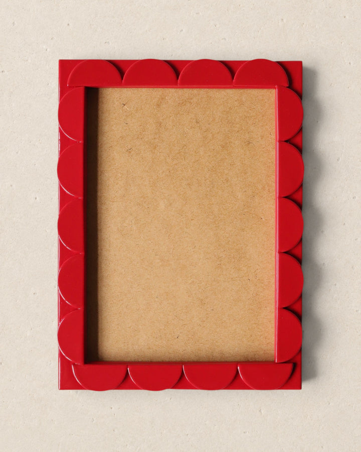 Red scalloped picture frame on a beige background