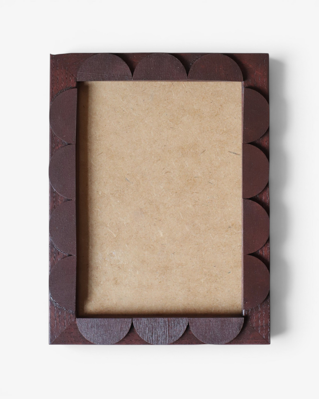 Brown decorative photo frame with scalloped edge on a white background