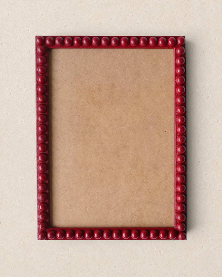 Red beaded picture frame on a beige background