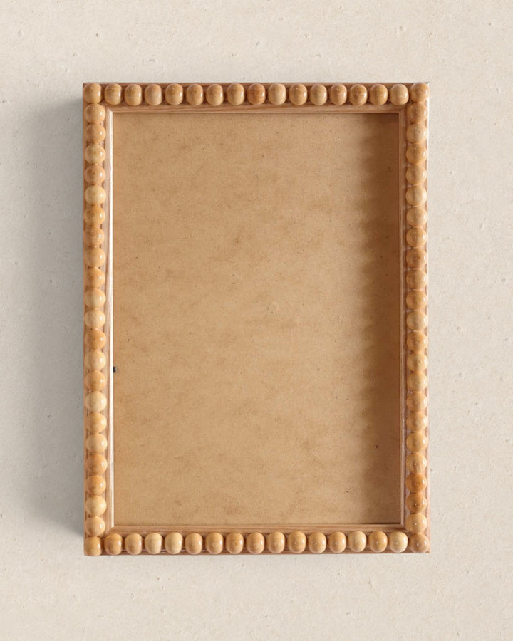 Rectangular wooden frame with decorative border on a beige background