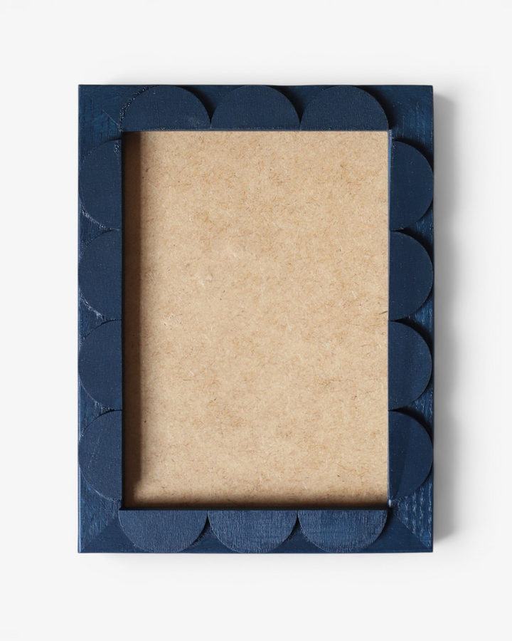 Navy blue scalloped picture frame on a white background
