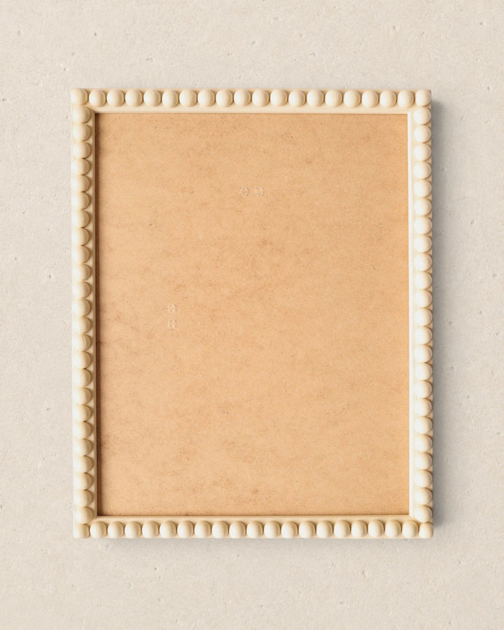 Wooden picture frame with decorative edge on a beige background