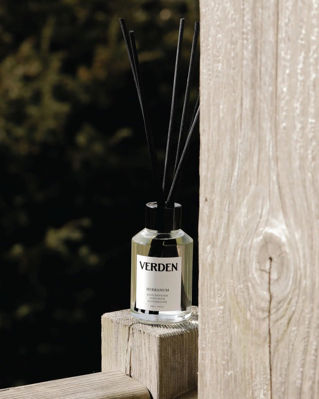 Verden reed diffuser on piece of wood with green outdoor background