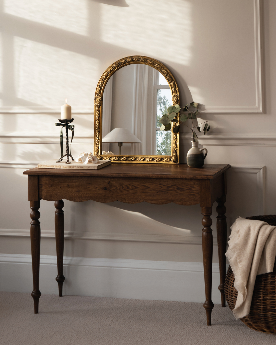 Wooden desk with mirror and candle against neutral wall