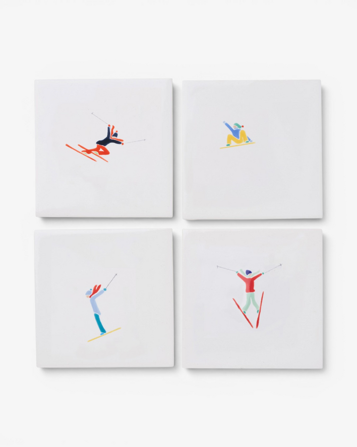 Four coasters with skiing designs on a white background