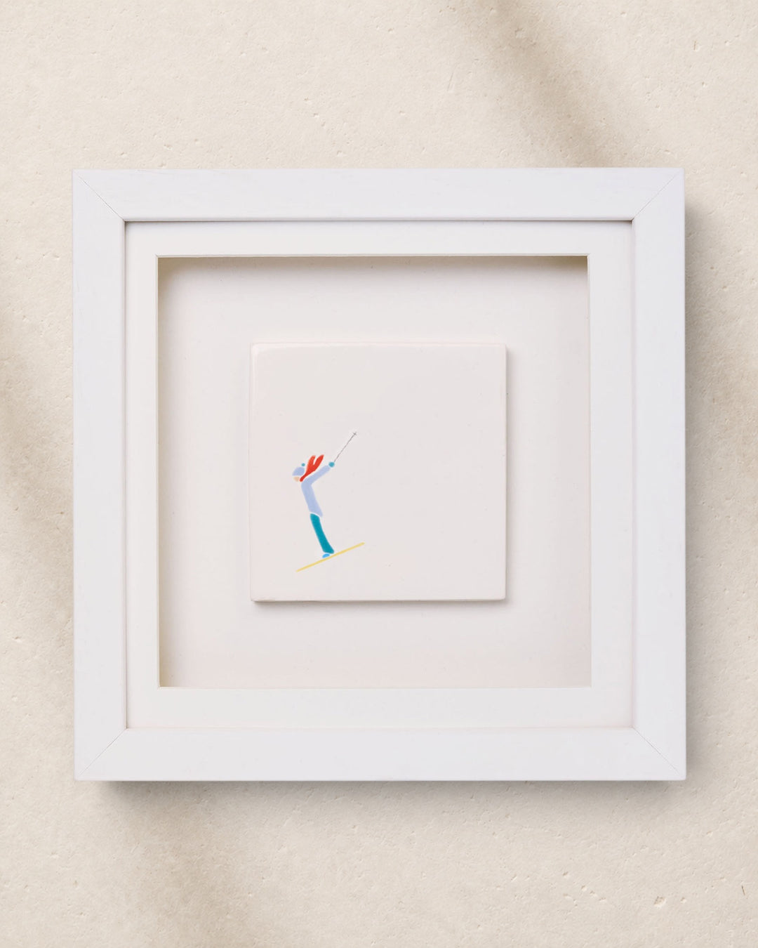 Framed artwork of a skier on a beige wall