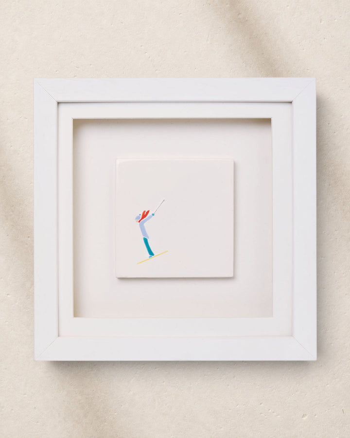 Framed artwork of a skier on a beige wall