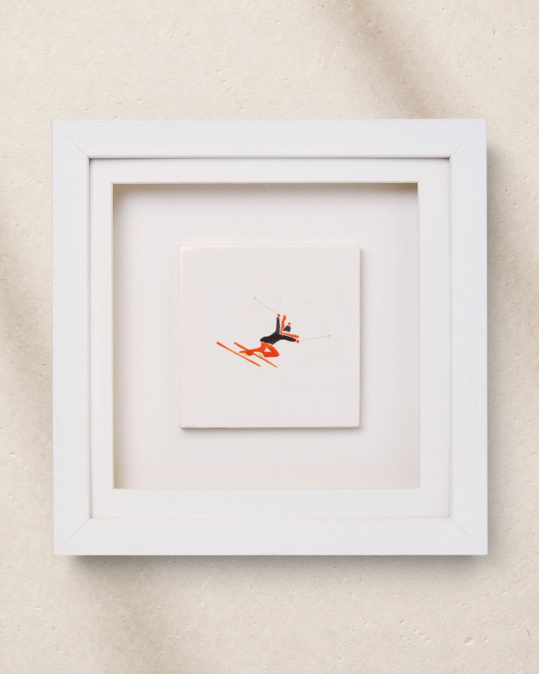 Framed artwork with a small abstract painting inside on a beige background