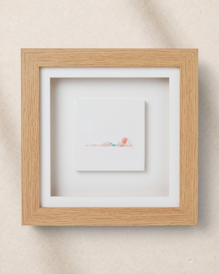 Framed artwork with a white border on a beige wall
