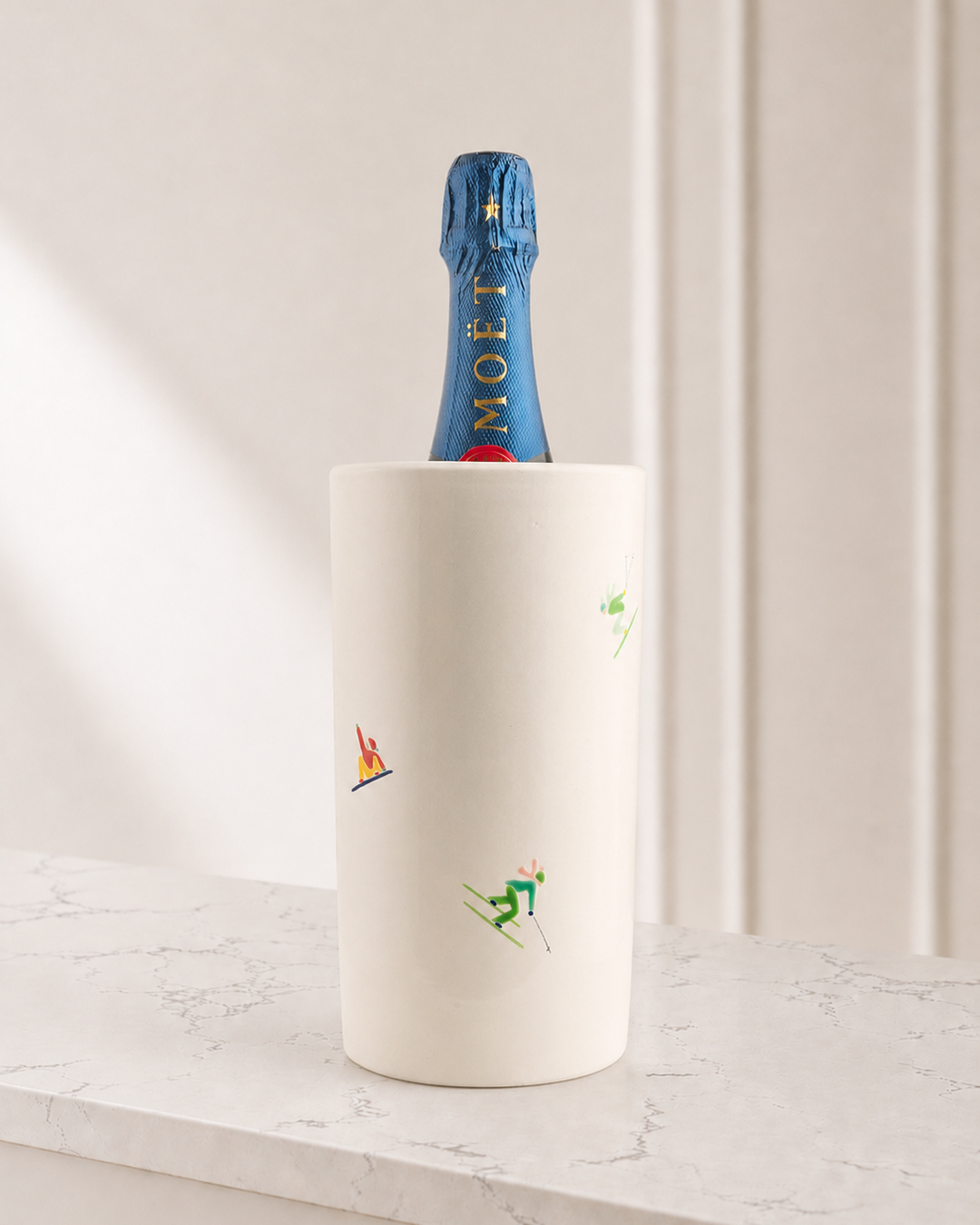 Moët champagne bottle in a decorative cooler on a marble surface