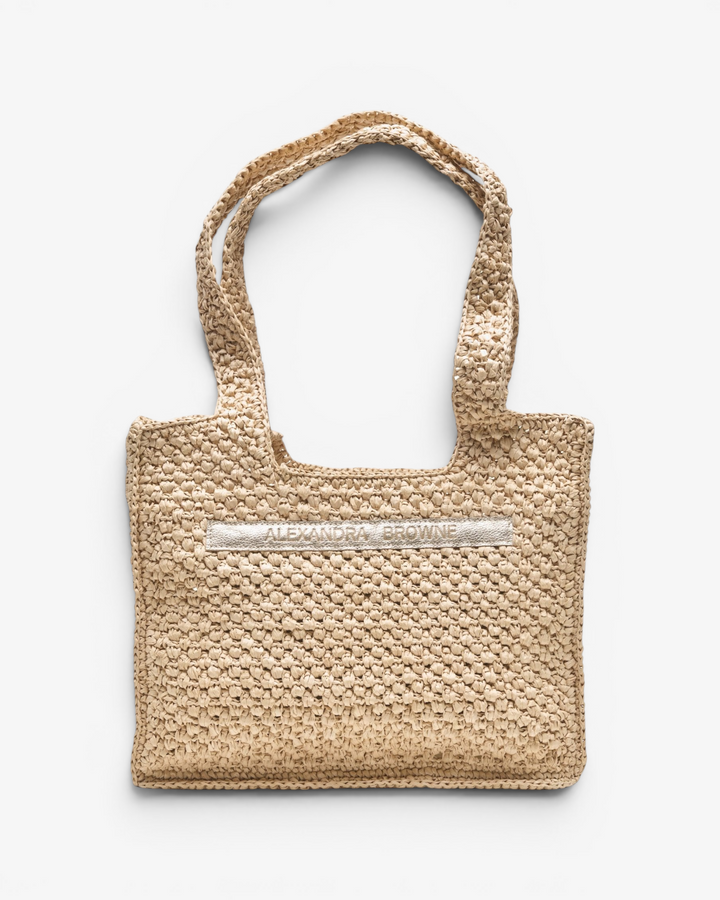 Woven handbag with a metallic logo on a white background