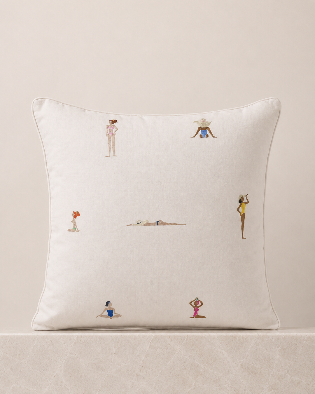 Decorative pillow with embroidered figures on a beige background
