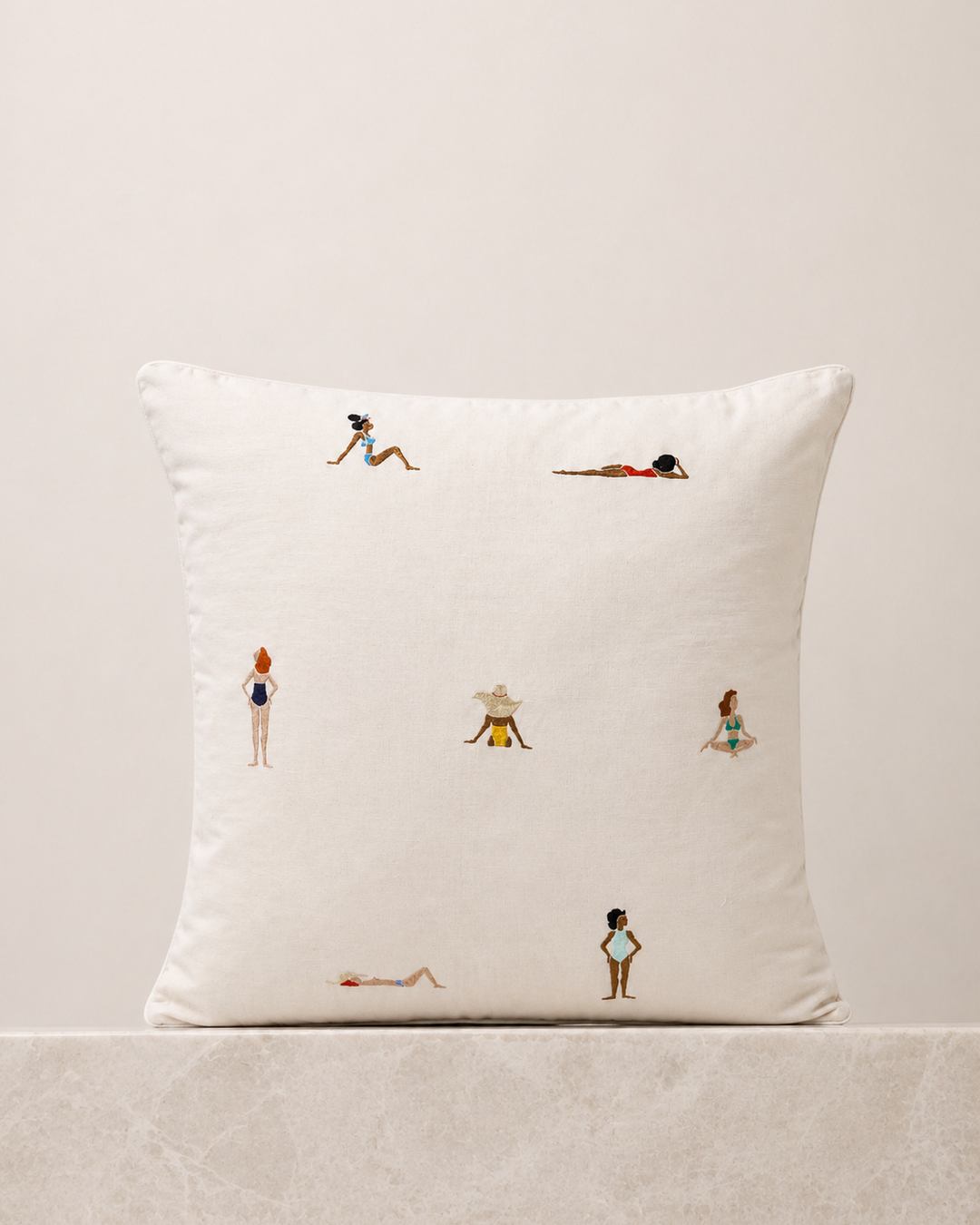 Decorative pillow with small illustrations of people on a neutral background
