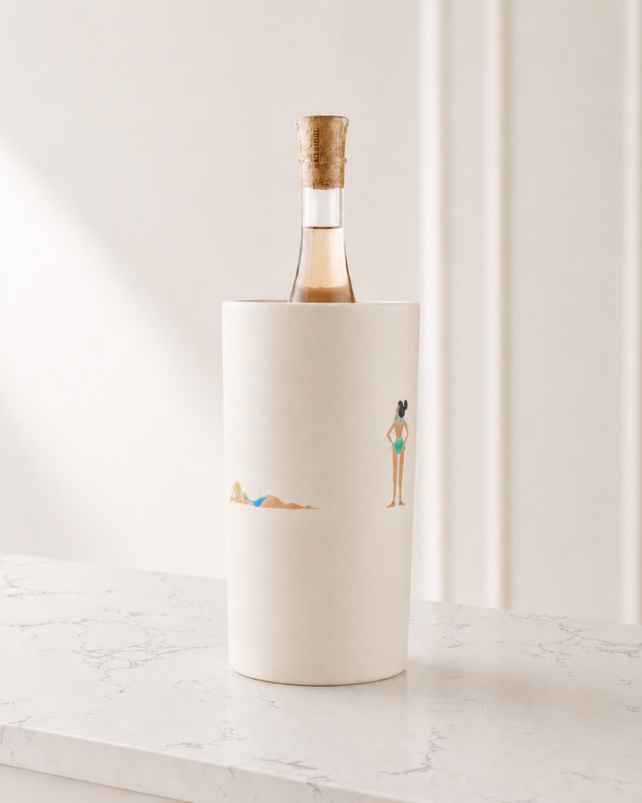 White wine bottle cooler with illustrations of people on a marble surface
