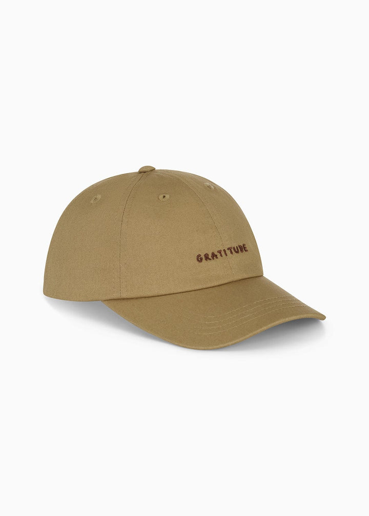 Beige cap with 'GRATITUDE' branding on a white background