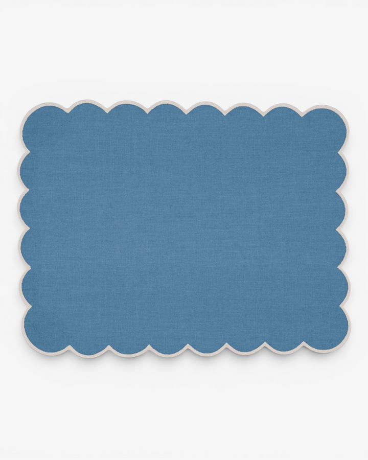 Blue placemat with scalloped border on a white background
