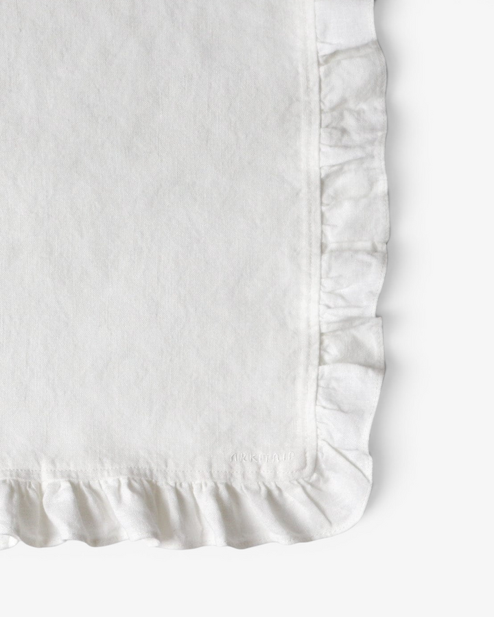 Close up of a white ruffled napkin on a white background