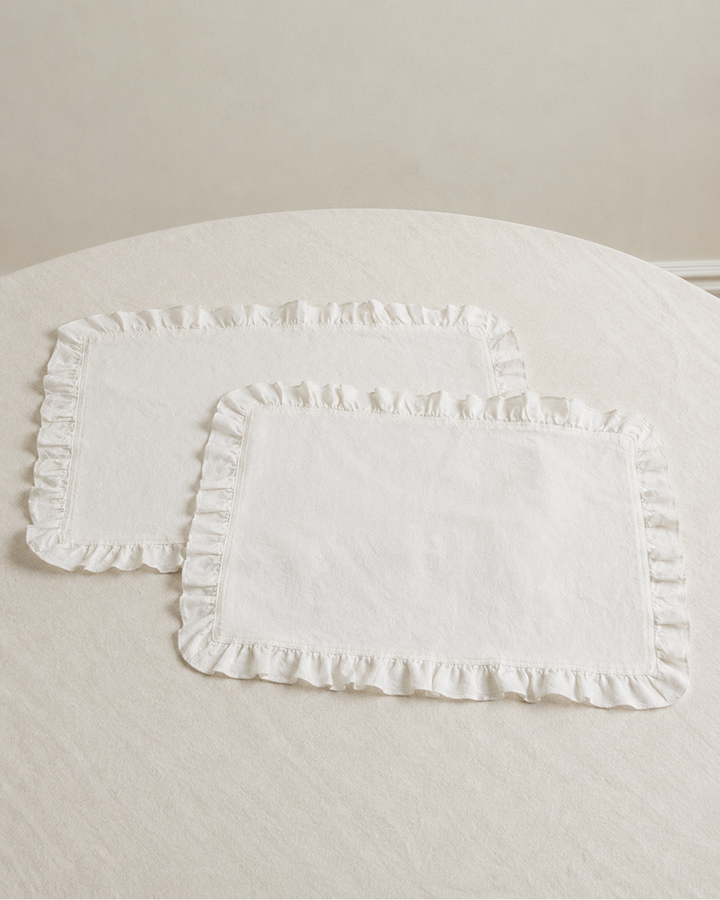White ruffled headboard on a bed with a neutral background