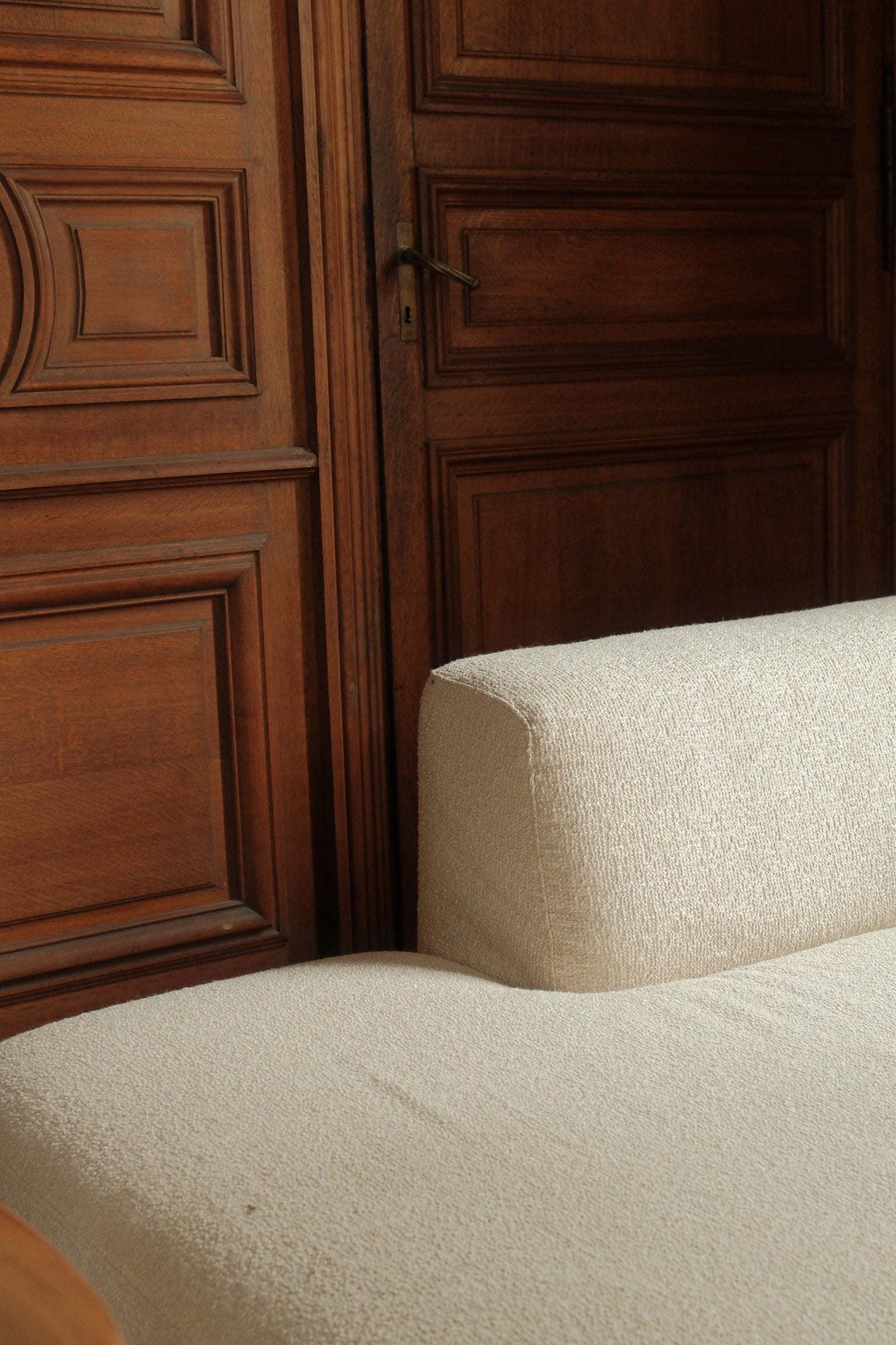 Close-up of a textured beige surface next to wooden paneling