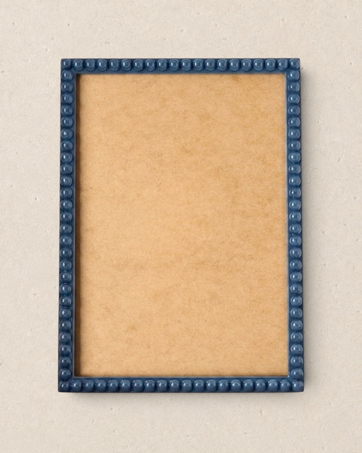 Picture frame with blue border on a beige background