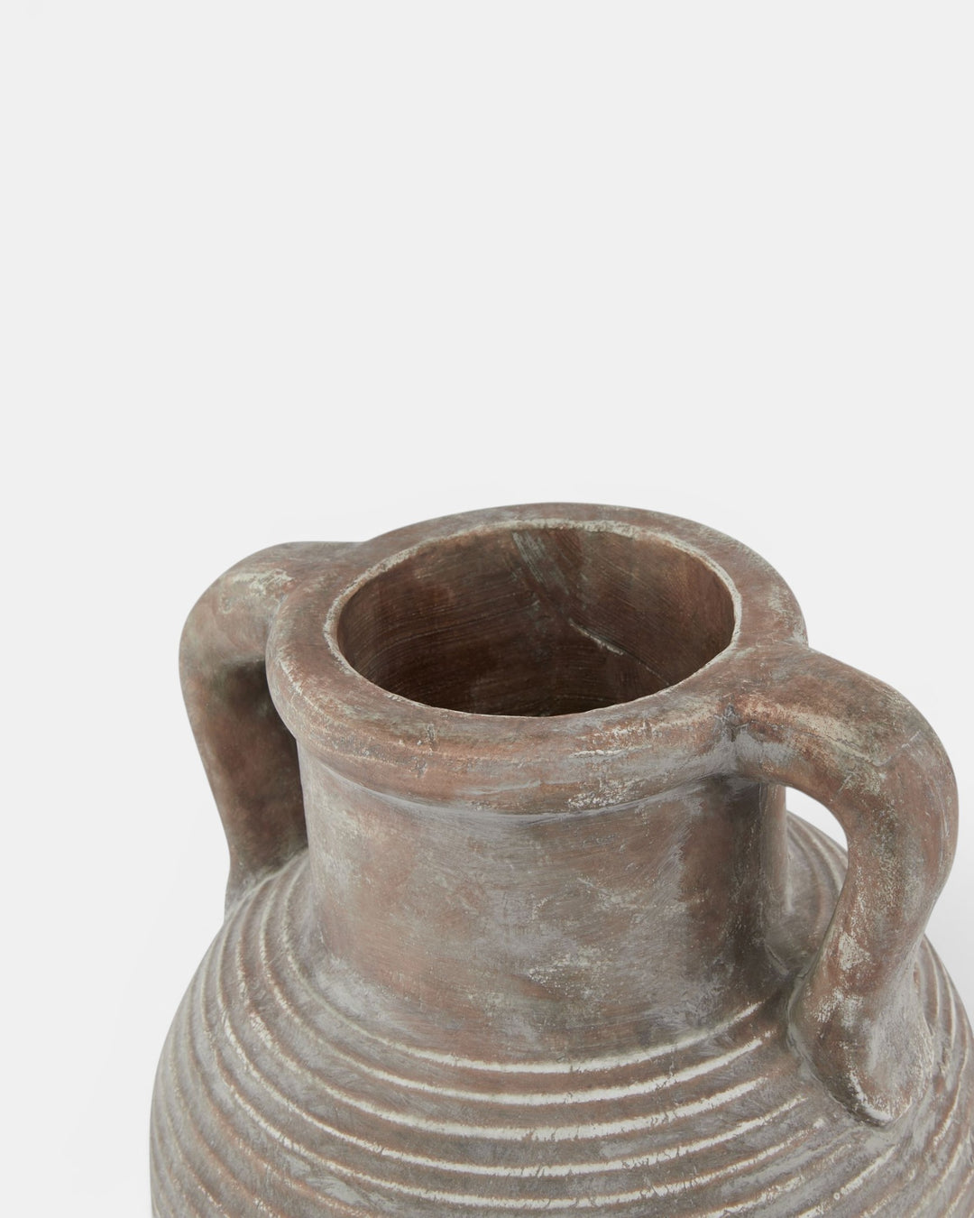 Terracotta vase with handles on a light gray background