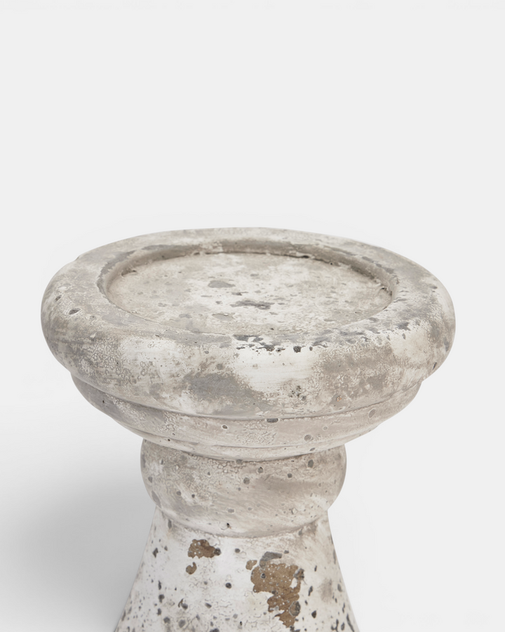 Beige candle holder with textured surface on a white background