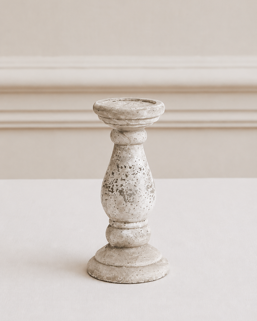 Decorative candle holder on a white surface with a neutral background