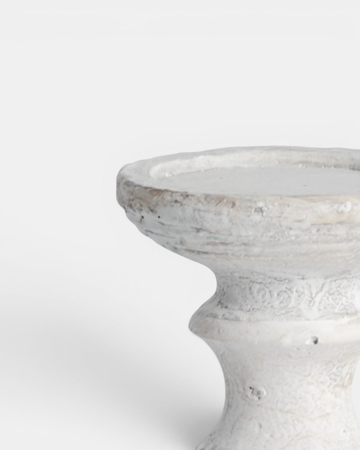 Cream candle holder with textured surface on a white background