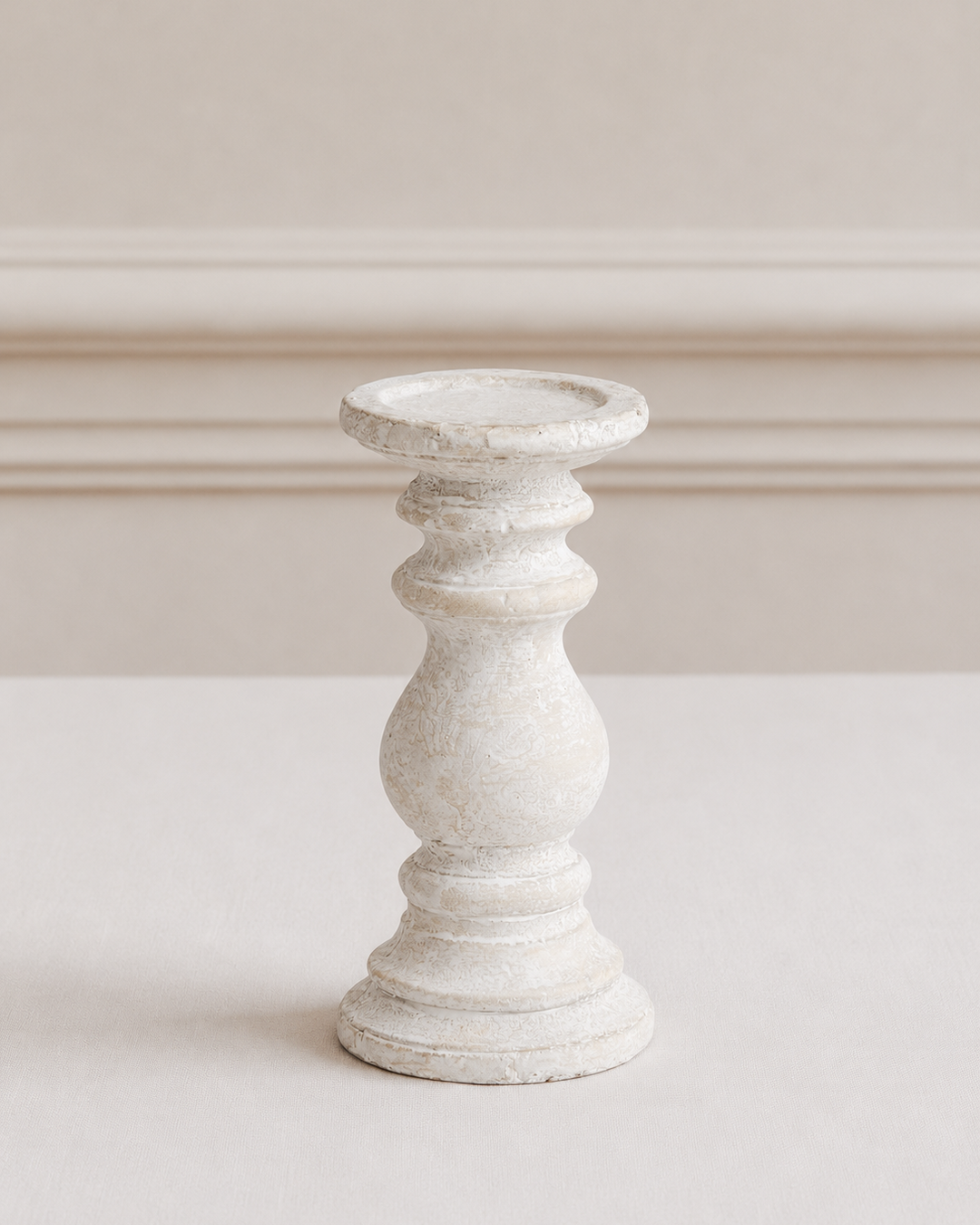 White ceramic candle holder on white table with neutral background