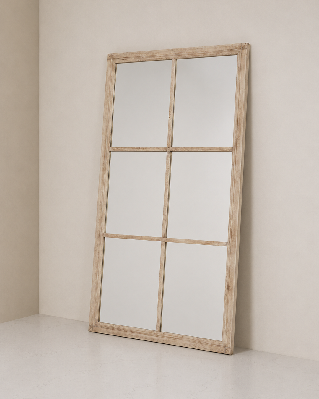 Large wooden-framed mirror leaning against a beige wall.